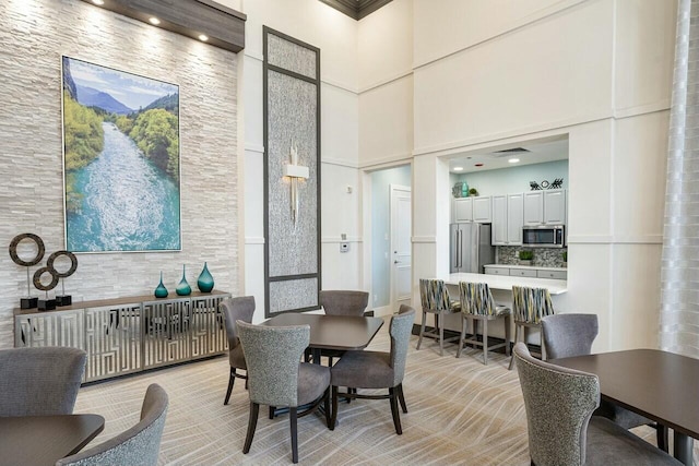 dining space featuring a high ceiling and visible vents