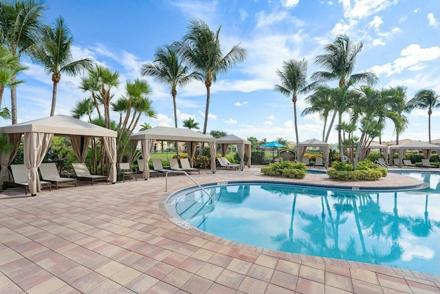 community pool with a gazebo and a patio