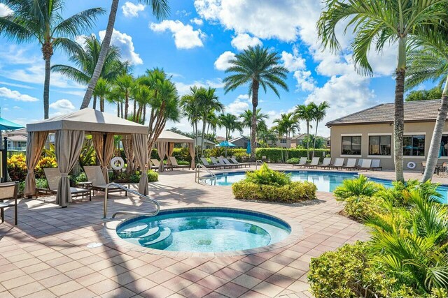 pool featuring a gazebo, a hot tub, and a patio