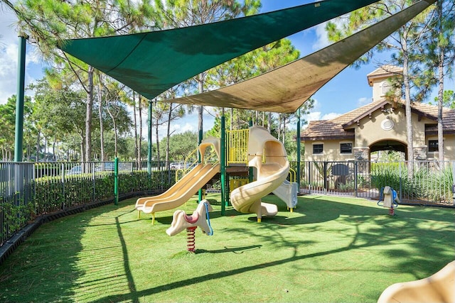 community jungle gym with a lawn and fence