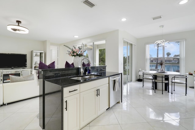 kitchen with light tile patterned flooring, sink, white cabinetry, hanging light fixtures, and dishwasher