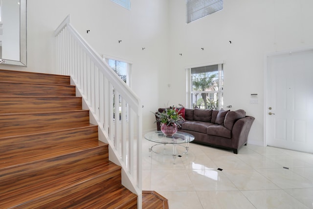 stairs featuring a towering ceiling and tile patterned floors