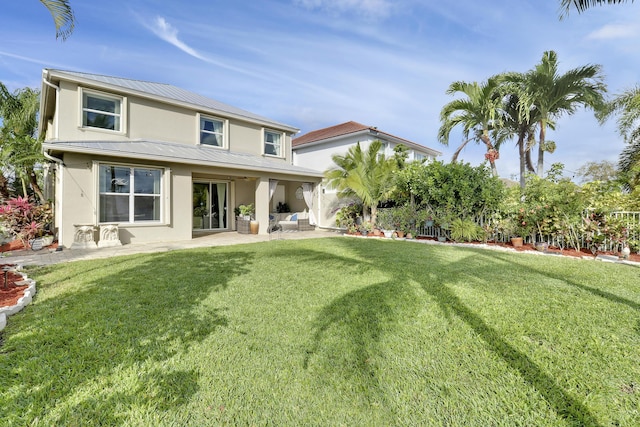 back of house featuring a patio area and a lawn