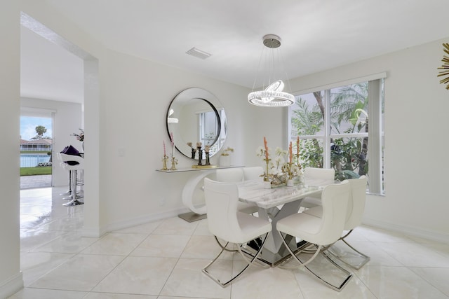 tiled dining area featuring a notable chandelier