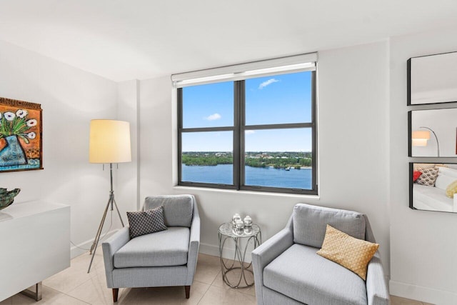 sitting room featuring a water view and light tile patterned floors