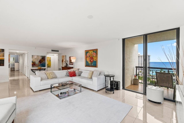 tiled living room with a water view and floor to ceiling windows