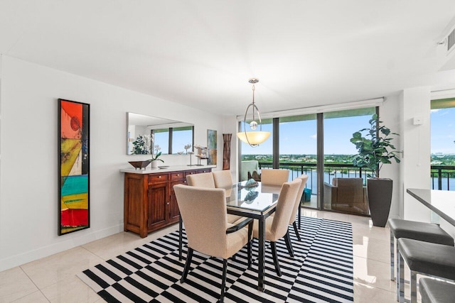 dining room featuring light tile patterned floors, plenty of natural light, floor to ceiling windows, and a water view