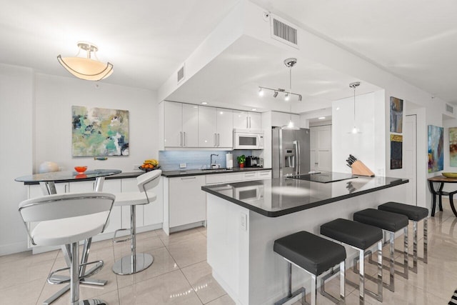 kitchen featuring stainless steel refrigerator with ice dispenser, white cabinetry, tasteful backsplash, black electric cooktop, and pendant lighting