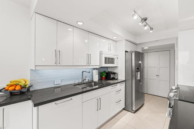 kitchen featuring light tile patterned flooring, sink, tasteful backsplash, stainless steel appliances, and white cabinets