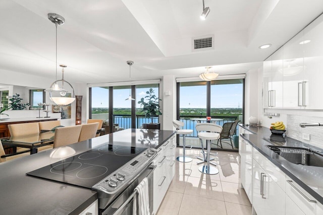 kitchen featuring white cabinetry, sink, stainless steel electric range oven, and a water view