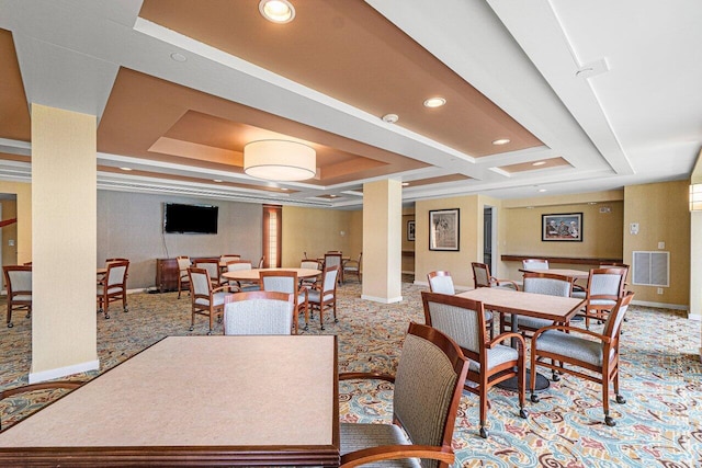 dining room featuring coffered ceiling, a tray ceiling, light carpet, and ornate columns