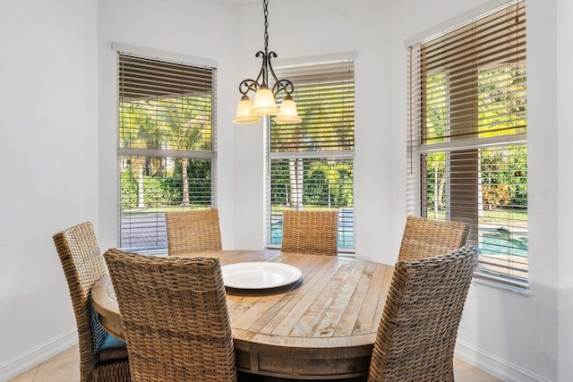 8187 Mariano Falls Ln, Boynton Beach, FL 33473 - tiled dining space with plenty of natural light, baseboards, and an inviting chandelier