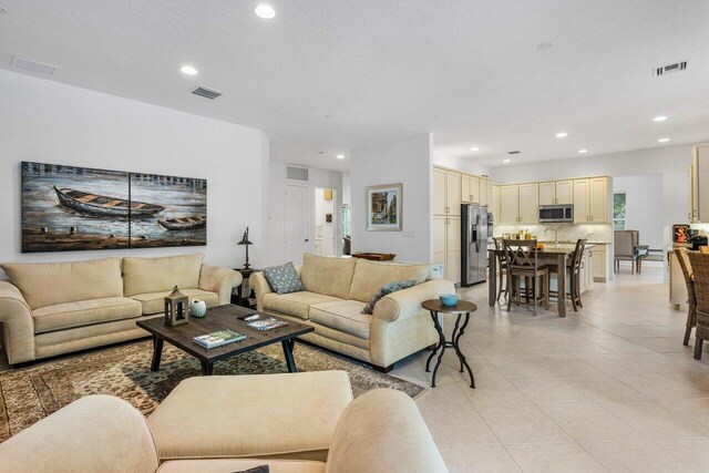 8187 Mariano Falls Ln, Boynton Beach, FL 33473 - living room with light tile patterned floors, visible vents, and recessed lighting