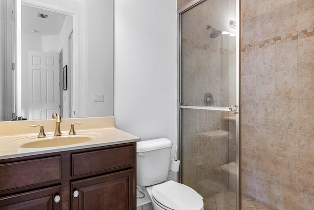 bathroom with a shower with door, vanity, and toilet