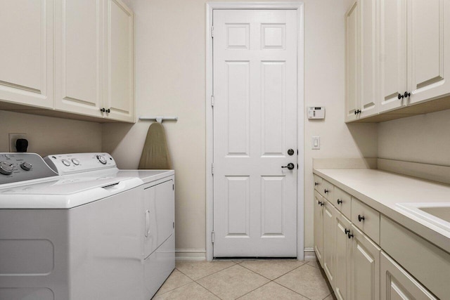 washroom with cabinets, washer and dryer, and light tile patterned floors