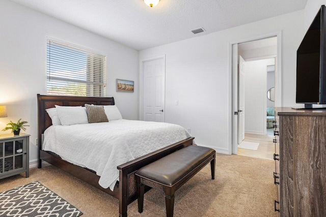 carpeted bedroom featuring a textured ceiling