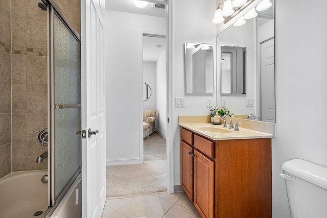 full bathroom featuring bath / shower combo with glass door, vanity, tile patterned floors, and toilet