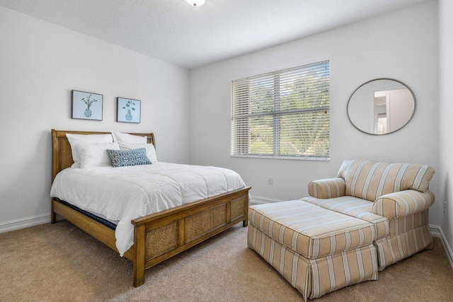 bedroom featuring light colored carpet and a textured ceiling