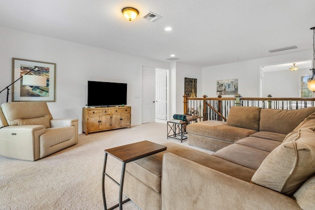 living room featuring light carpet and a textured ceiling