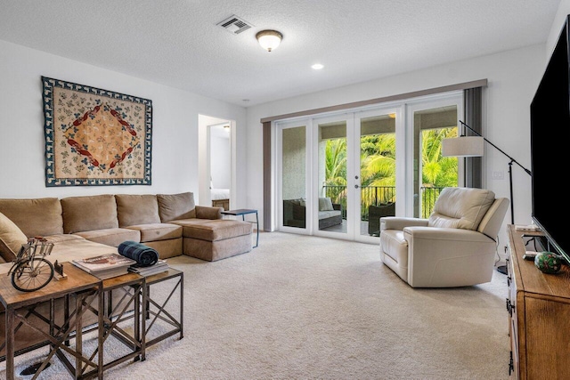 living room with light carpet, french doors, and a textured ceiling