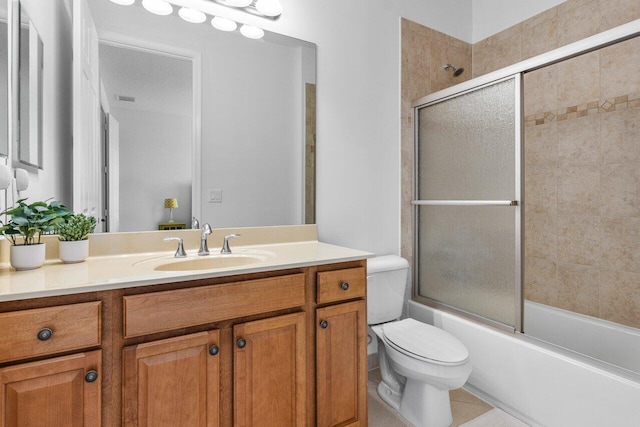 full bathroom featuring vanity, tile patterned floors, toilet, and combined bath / shower with glass door