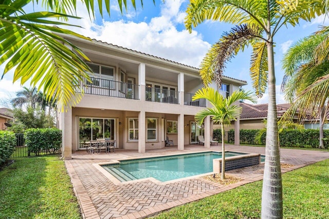 rear view of house featuring a balcony, a fenced in pool, and a patio