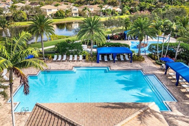 view of swimming pool with a patio area and a water view