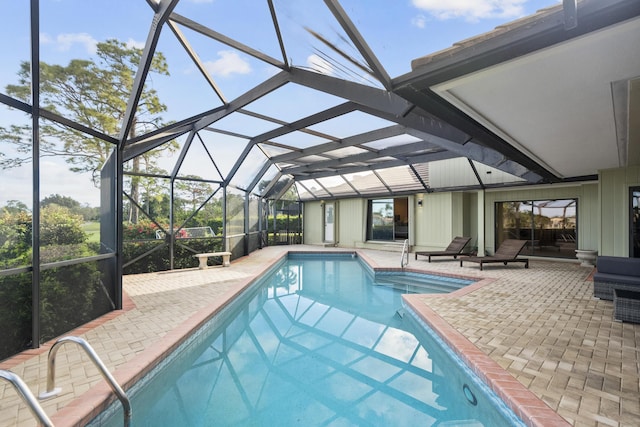 view of swimming pool featuring glass enclosure and a patio area