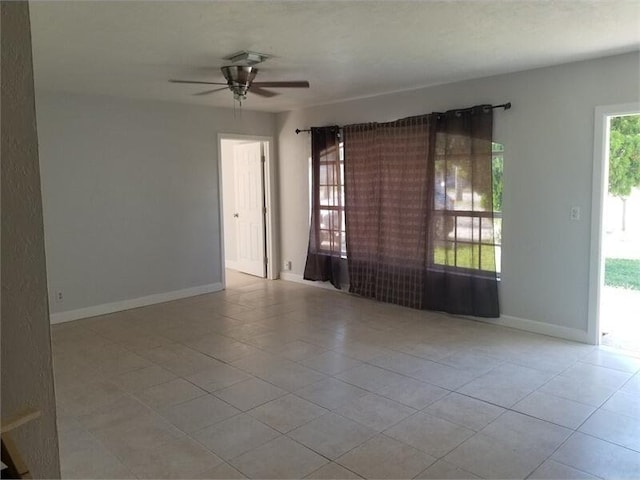 tiled spare room with ceiling fan