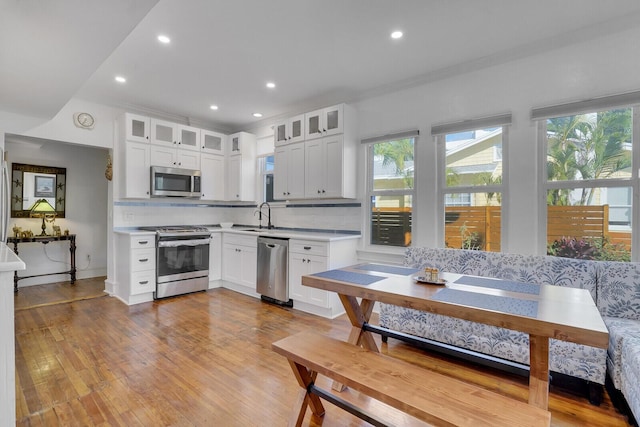 kitchen with white cabinetry, appliances with stainless steel finishes, sink, and backsplash