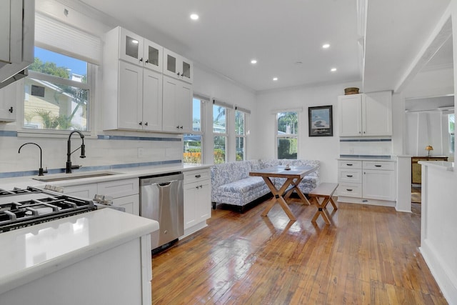 kitchen with white cabinetry, sink, light hardwood / wood-style floors, and dishwasher