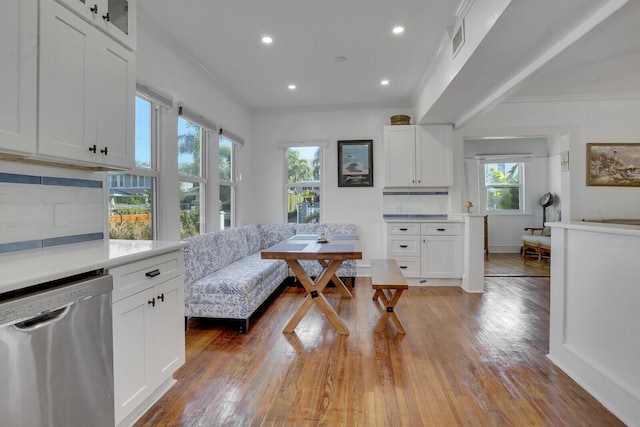 interior space with crown molding, dark wood-type flooring, stainless steel dishwasher, and white cabinets