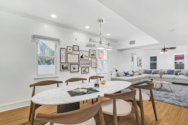 dining area featuring crown molding, light hardwood / wood-style floors, and ceiling fan