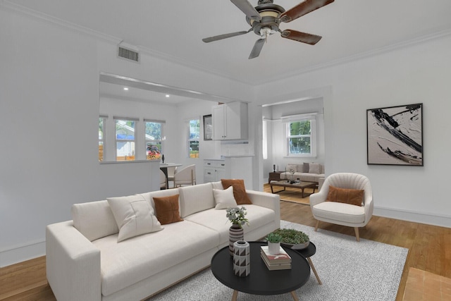 living room featuring crown molding, ceiling fan, and light wood-type flooring