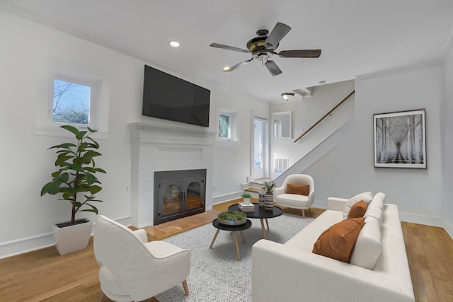 living room with ceiling fan, plenty of natural light, and light hardwood / wood-style floors