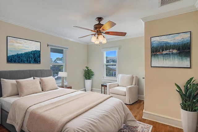 bedroom featuring hardwood / wood-style flooring, ornamental molding, and ceiling fan