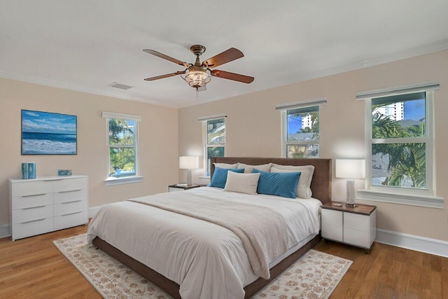 bedroom with ceiling fan, ornamental molding, and hardwood / wood-style floors