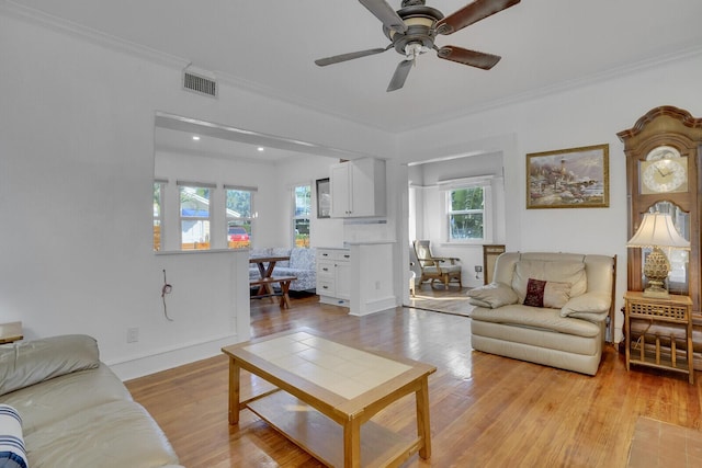 living room with ornamental molding, ceiling fan, and light hardwood / wood-style floors