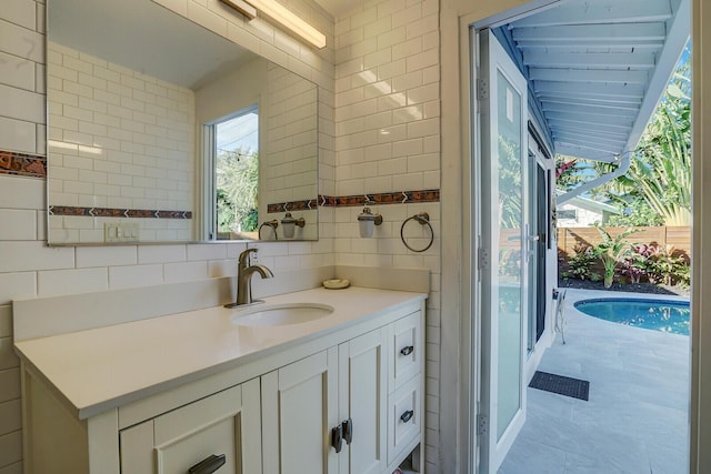 bathroom with vanity, tile walls, and decorative backsplash