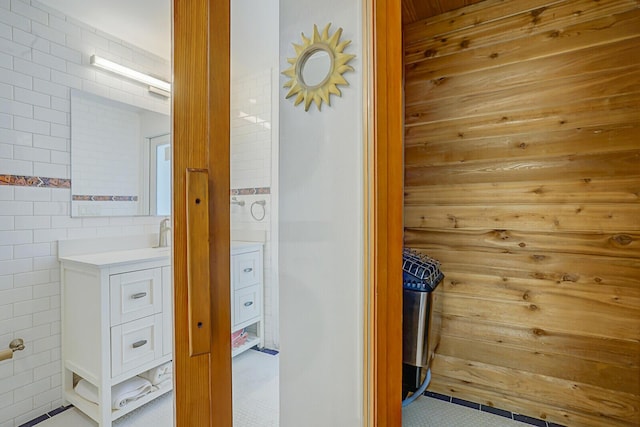 bathroom with vanity and tile walls