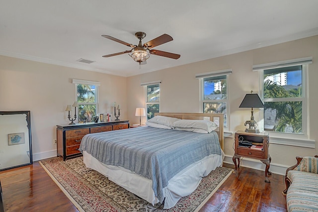 bedroom with ceiling fan, ornamental molding, and dark hardwood / wood-style flooring