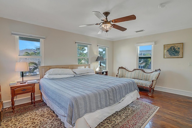 bedroom with ceiling fan, ornamental molding, and dark hardwood / wood-style flooring