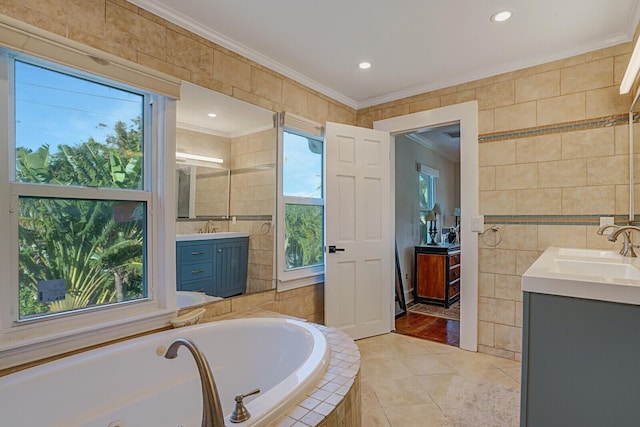 bathroom with crown molding, tile walls, vanity, a relaxing tiled tub, and tile patterned floors