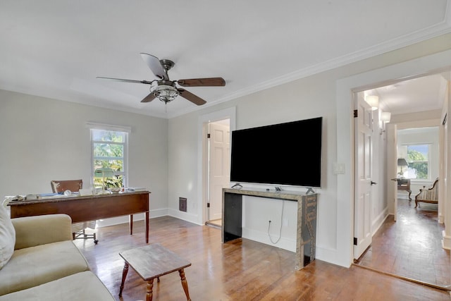 living room with ceiling fan, a healthy amount of sunlight, light hardwood / wood-style flooring, and ornamental molding