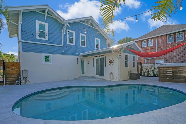 back of house featuring a fenced in pool and a patio area