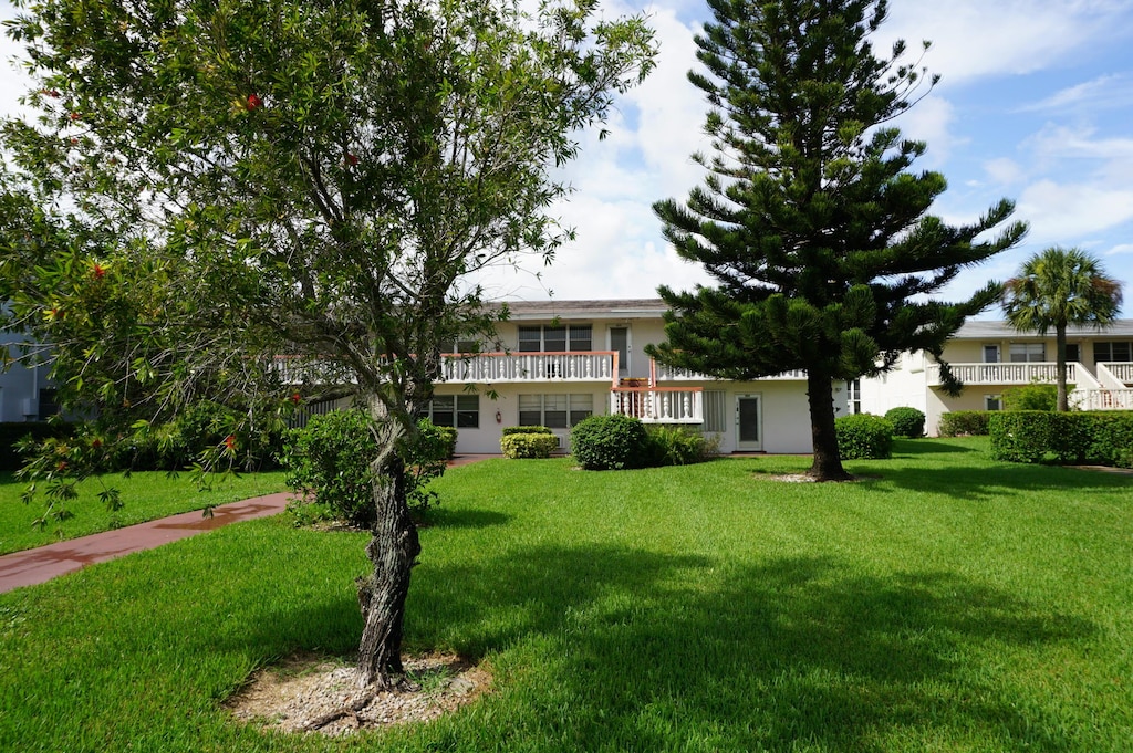 view of front of house with a balcony and a front yard