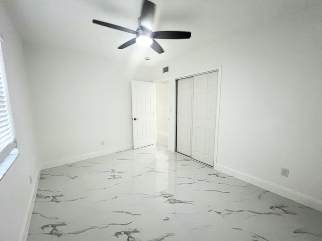 unfurnished bedroom with marble finish floor, visible vents, baseboards, and a closet