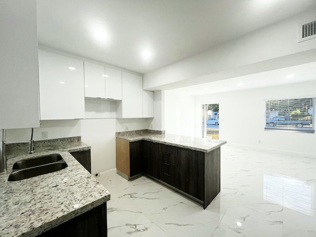 kitchen featuring light stone counters, marble finish floor, visible vents, white cabinetry, and modern cabinets