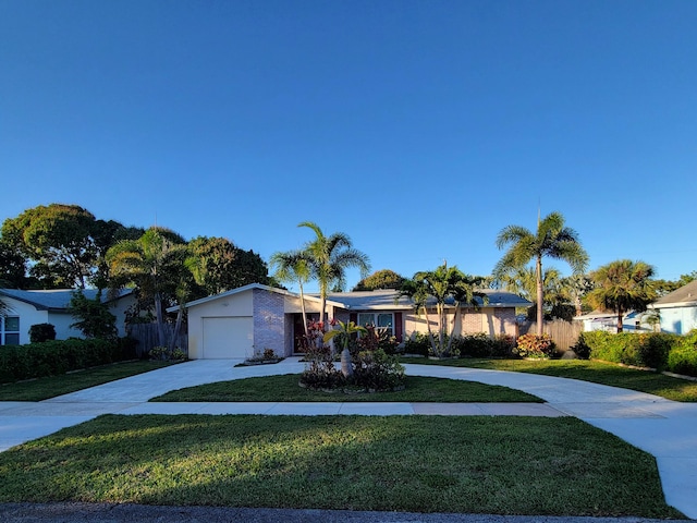 ranch-style home featuring a garage and a front lawn