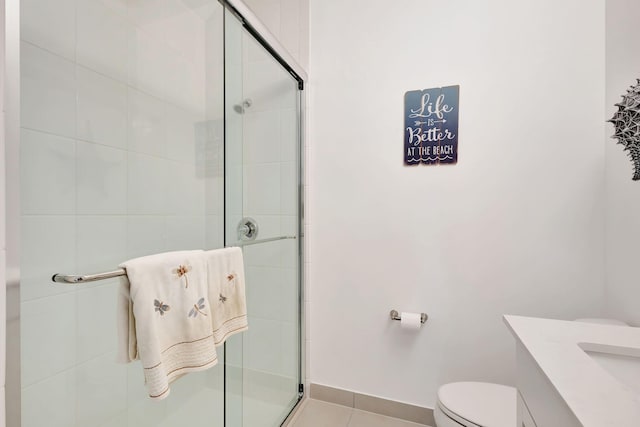 bathroom with tile patterned floors, toilet, a shower with shower door, and vanity